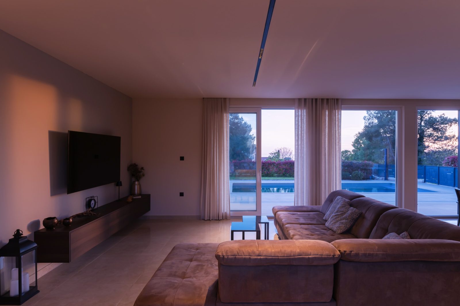 Villa Riflessi, soggiorno con divano e vetrata sulla piscina