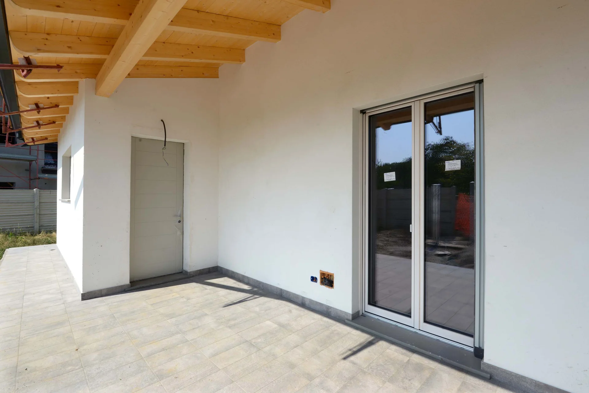 Spazio coperto con pavimentazione e struttura del tetto in legno