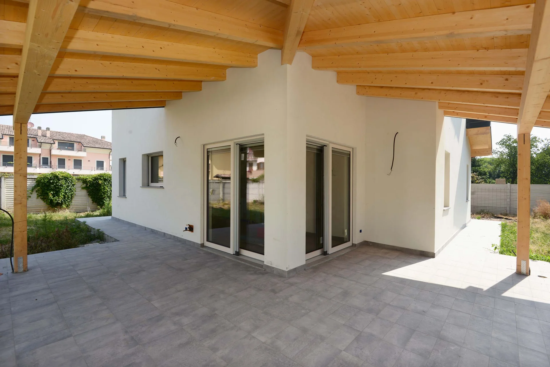 Travi in legno a vista e pilastri del porticato