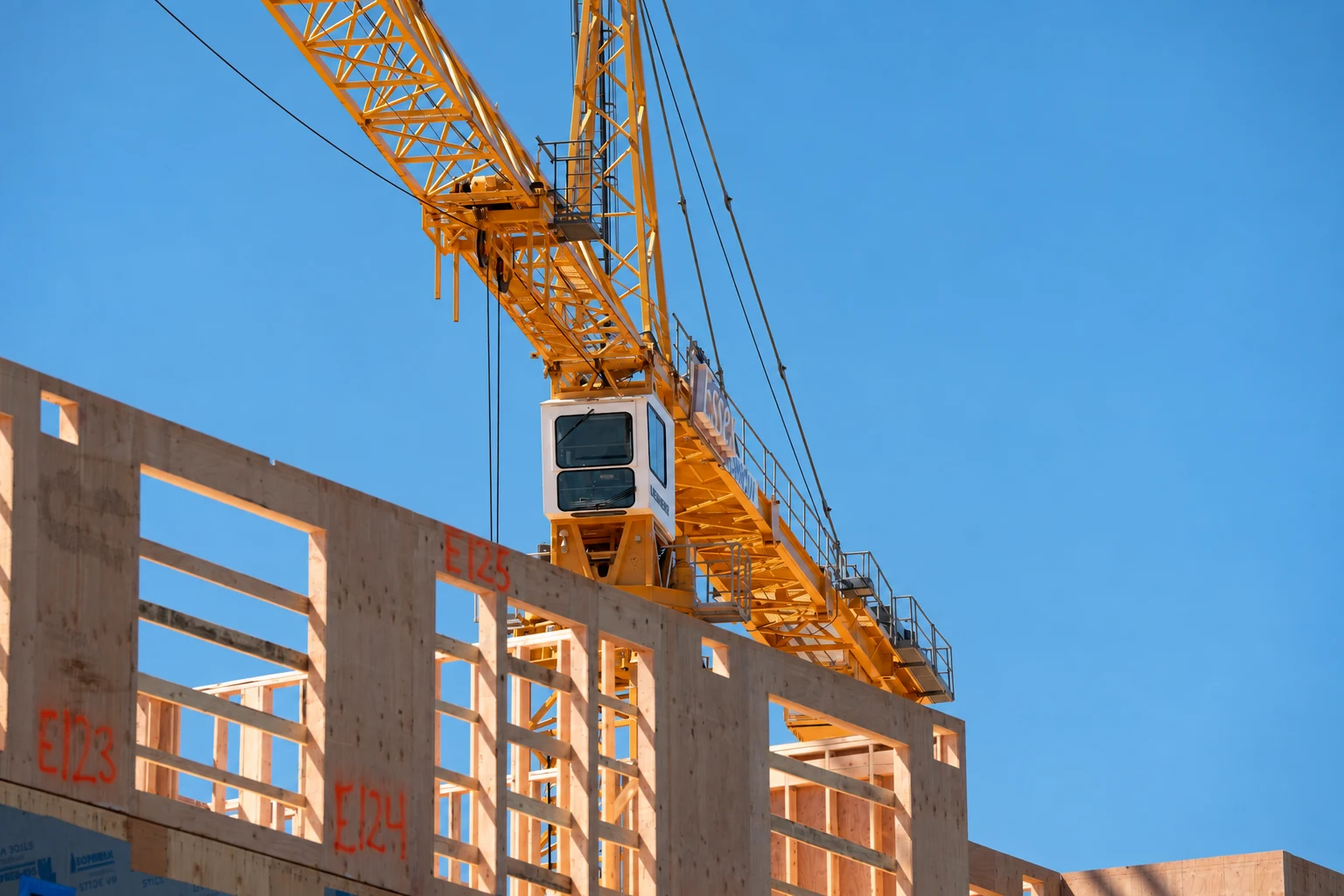 Gru e struttura in legno, senza persone inquadrate, fotografia rappresentativa del mondo del cantiere