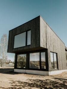 Casa contemporanea con rivestimento esterno in legno e grandi finestre, immagine illustrativa