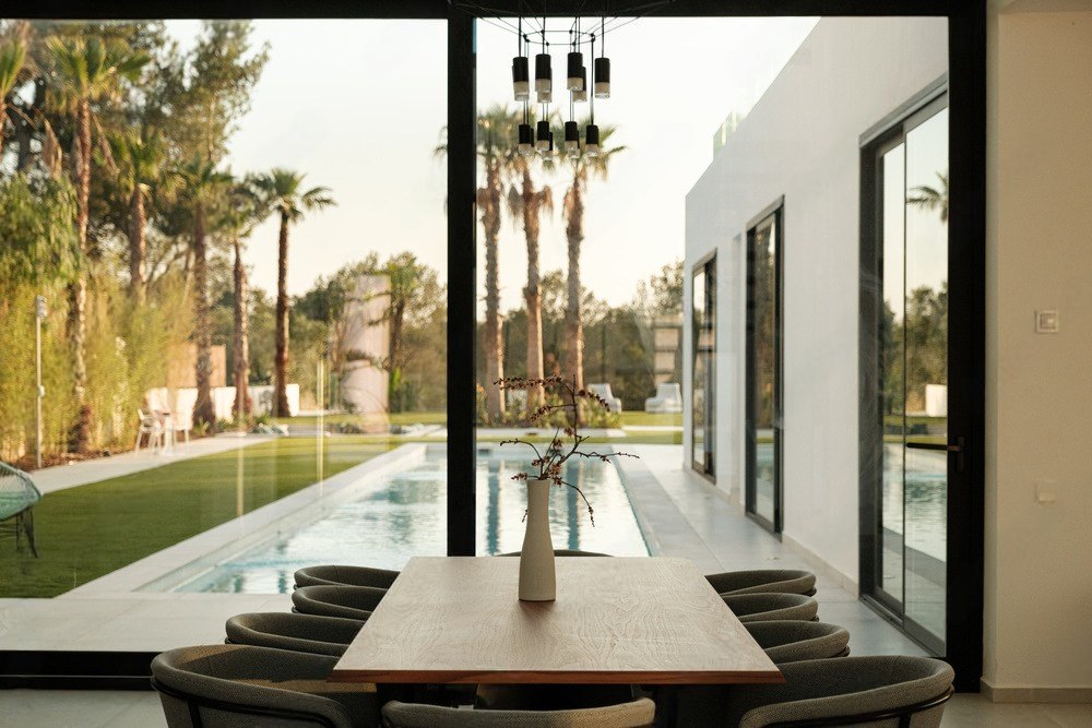 Villa Palmaria — Zona pranzo aperta sulla piscina e sulle palme