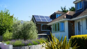 Pannelli fotovoltaici sul tetto di una casa con giardino
