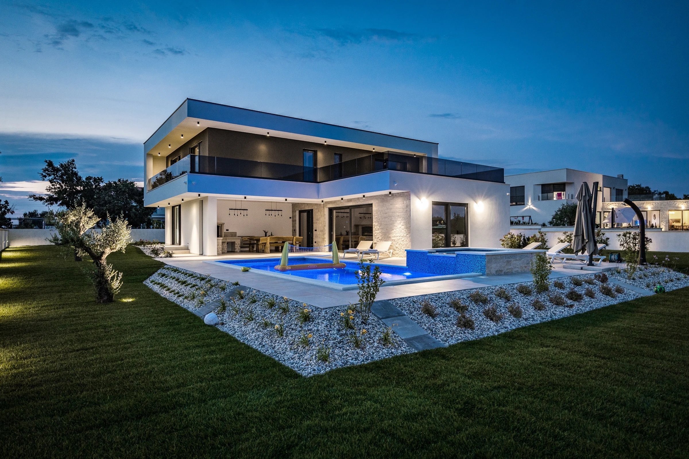 Villa Terrazze di Luce al crepuscolo con piscina illuminata, terrazze in vetro e giardino